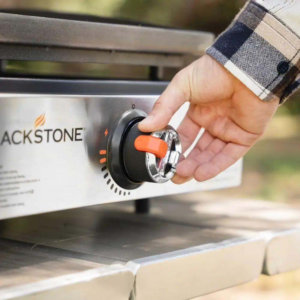 Close-up of the ignition knob on the Blackstone 17-inch stainless steel griddle, featuring adjustable heat control for precision cooking.