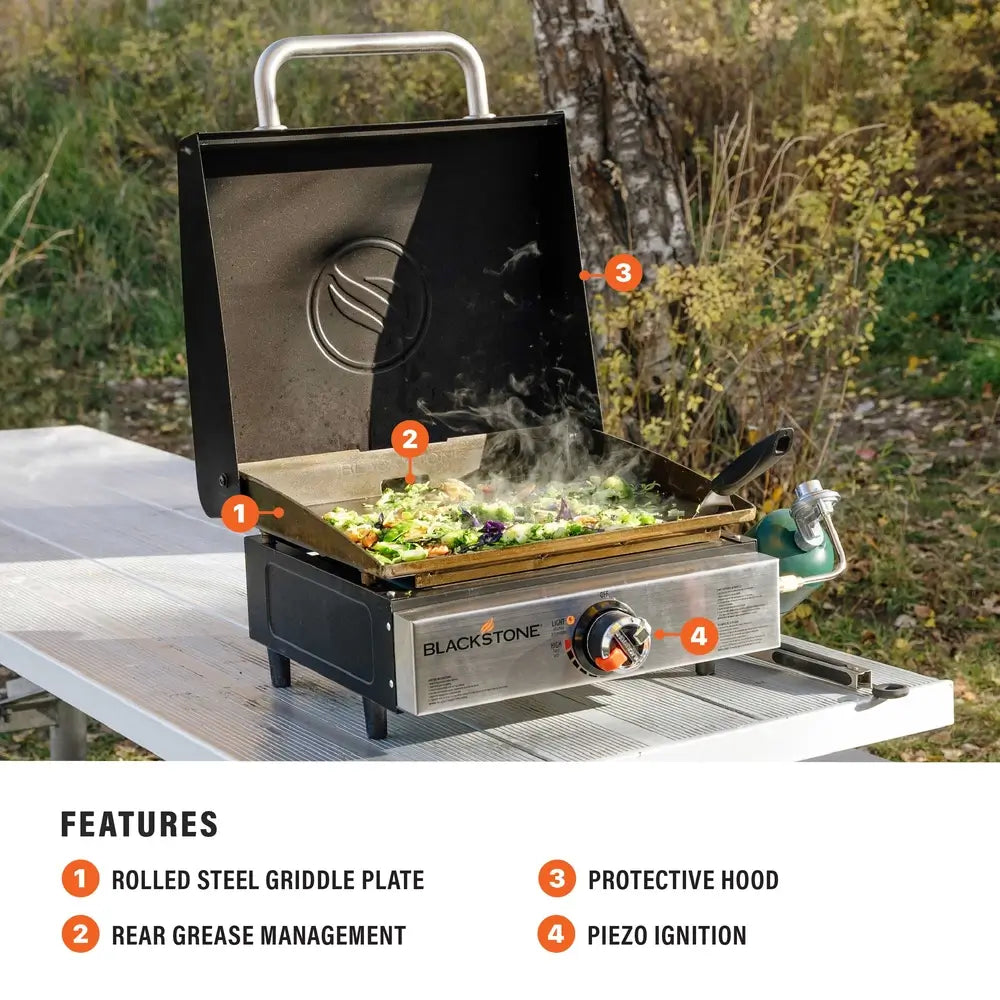 Blackstone 17-inch griddle with rolled steel cooking plate, rear grease trap, protective hood, and piezo ignition