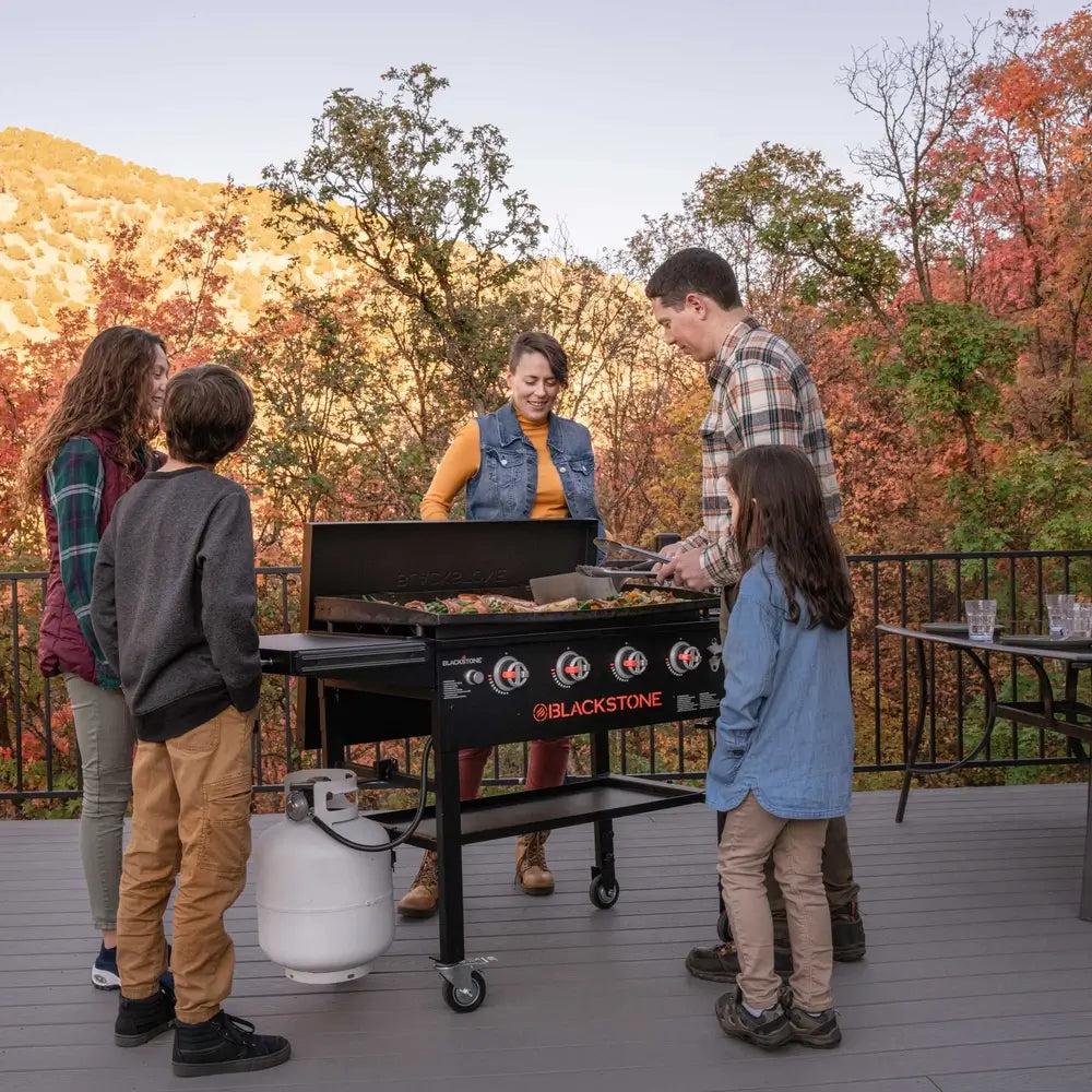 Family enjoying backyard cooking on Blackstone 36-inch stainless steel griddle with hood – perfect for outdoor gatherings and BBQ parties