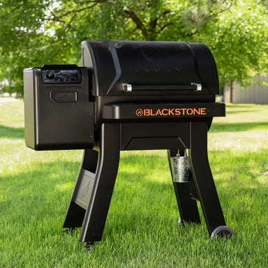 Blackstone 900 Pellet Grill with large hopper and bold logo, set on grassy backyard lawn under shade trees