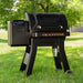 Blackstone 900 Pellet Grill with large hopper and bold logo, set on grassy backyard lawn under shade trees