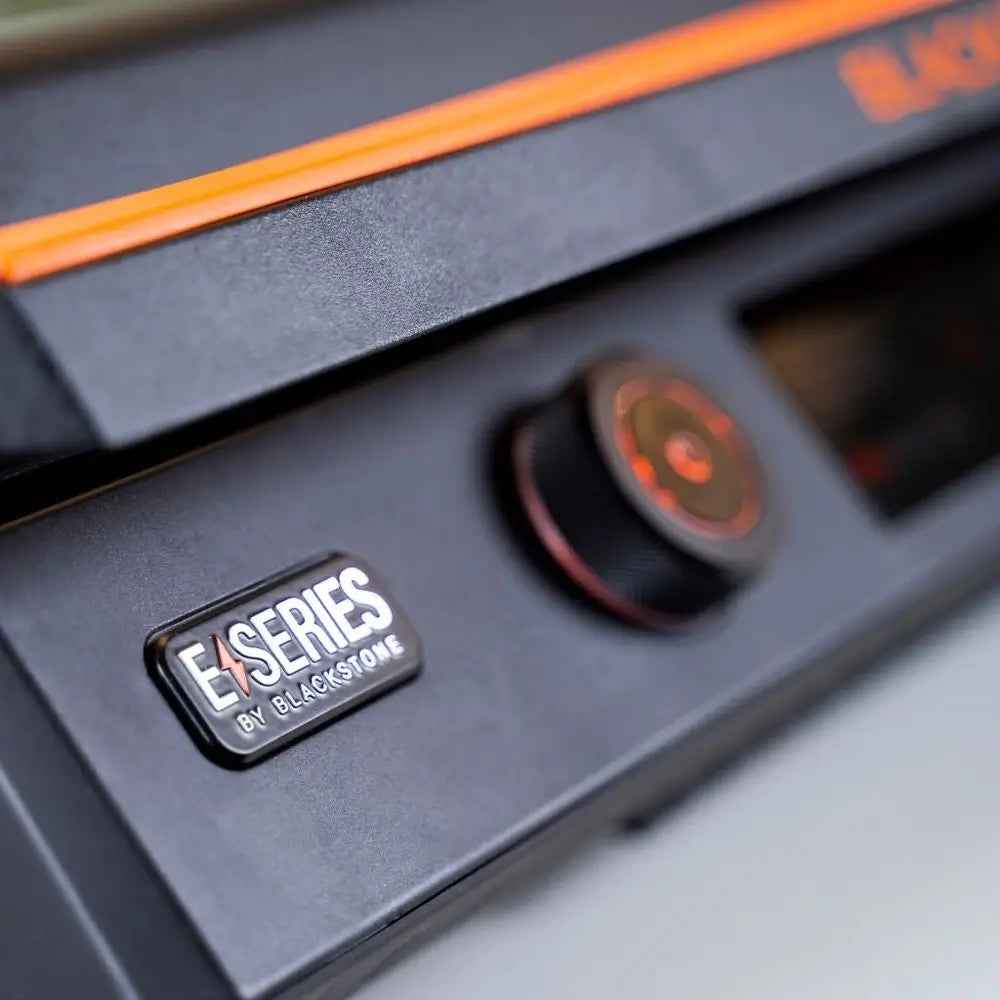 E-Series by Blackstone logo badge on the front panel of the 22-Inch electric griddle with power dial in view
