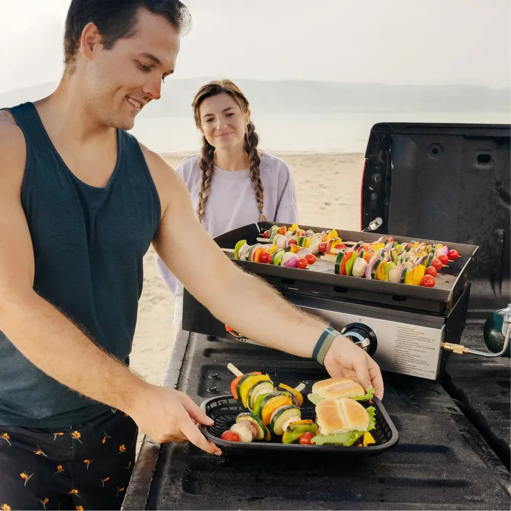 Serving Grilled Kabobs from Blackstone 22-Inch Outdoor Griddle at Beach Cookout