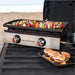 Blackstone 22in Griddle with skewers and burgers on a vehicle's open trunk.