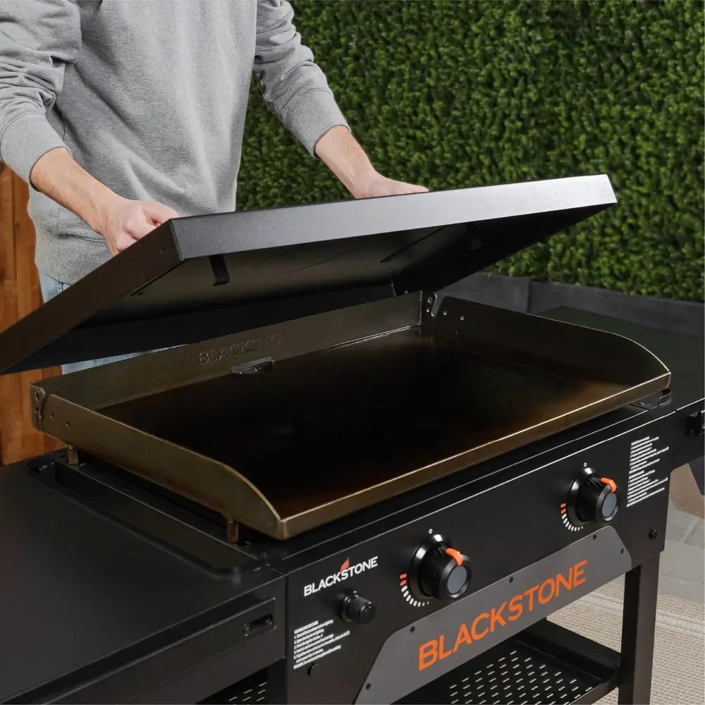 User Opening Lid of Blackstone 28-Inch Omni Griddle – Spacious Griddle Top for Family Grilling