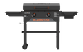 Blackstone 28-inch griddle grilling burgers and vegetables on dual heat zones with stainless hood and side shelves