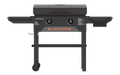 Blackstone 28-inch griddle grilling burgers and vegetables on dual heat zones with stainless hood and side shelves