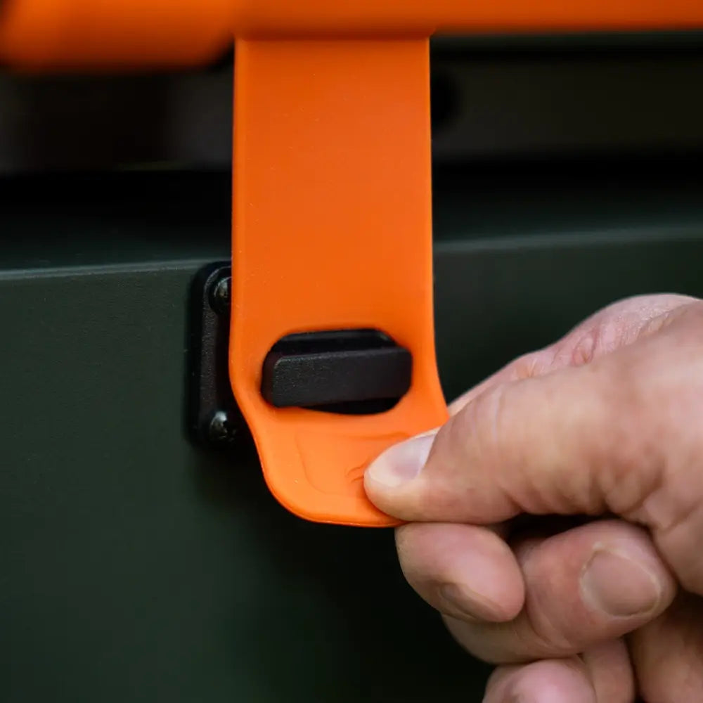 Close-up of secure orange latch on the Blackstone griddle hood for travel-ready locking mechanism