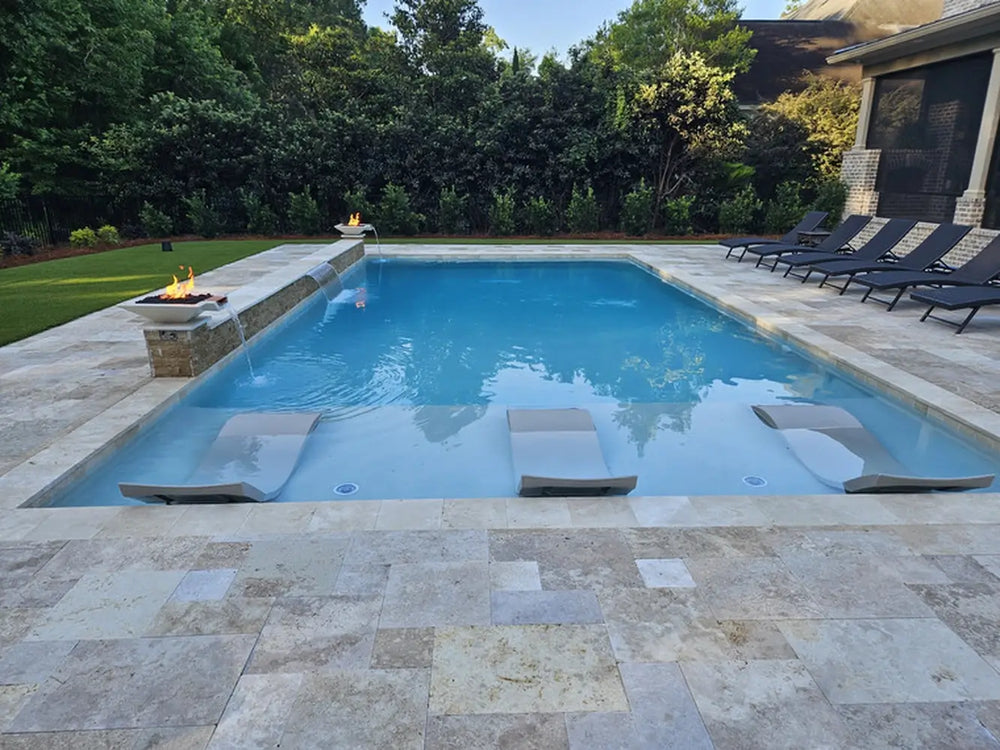 Travertine TessaRai Square Fire/Water Bowl Kit installed on modern pool with tanning ledge loungers and dual spillway features