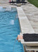 Travertine TessaRai Square Fire/Water Bowl Kit with copper scupper spillway beside luxury pool and sun shelf