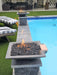 Pair of Travertine TessaRai Square Fire/Water Bowl Kits with lava rock flames on matching poolside pedestals