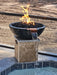 Travertine TessaRai fire and water bowl beside luxury pool with lava rock flames and cascading spillway.