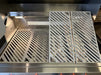 Interior view of the grill showing two KoKoMo LuxCut laser-cut cooking grates installed and two additional grate sections propped up, highlighting the modular design.