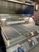 KoKoMo LuxCut laser-cut cooking grates installed in a stainless steel gas grill, viewed from the front with the hood open and interior lights on.