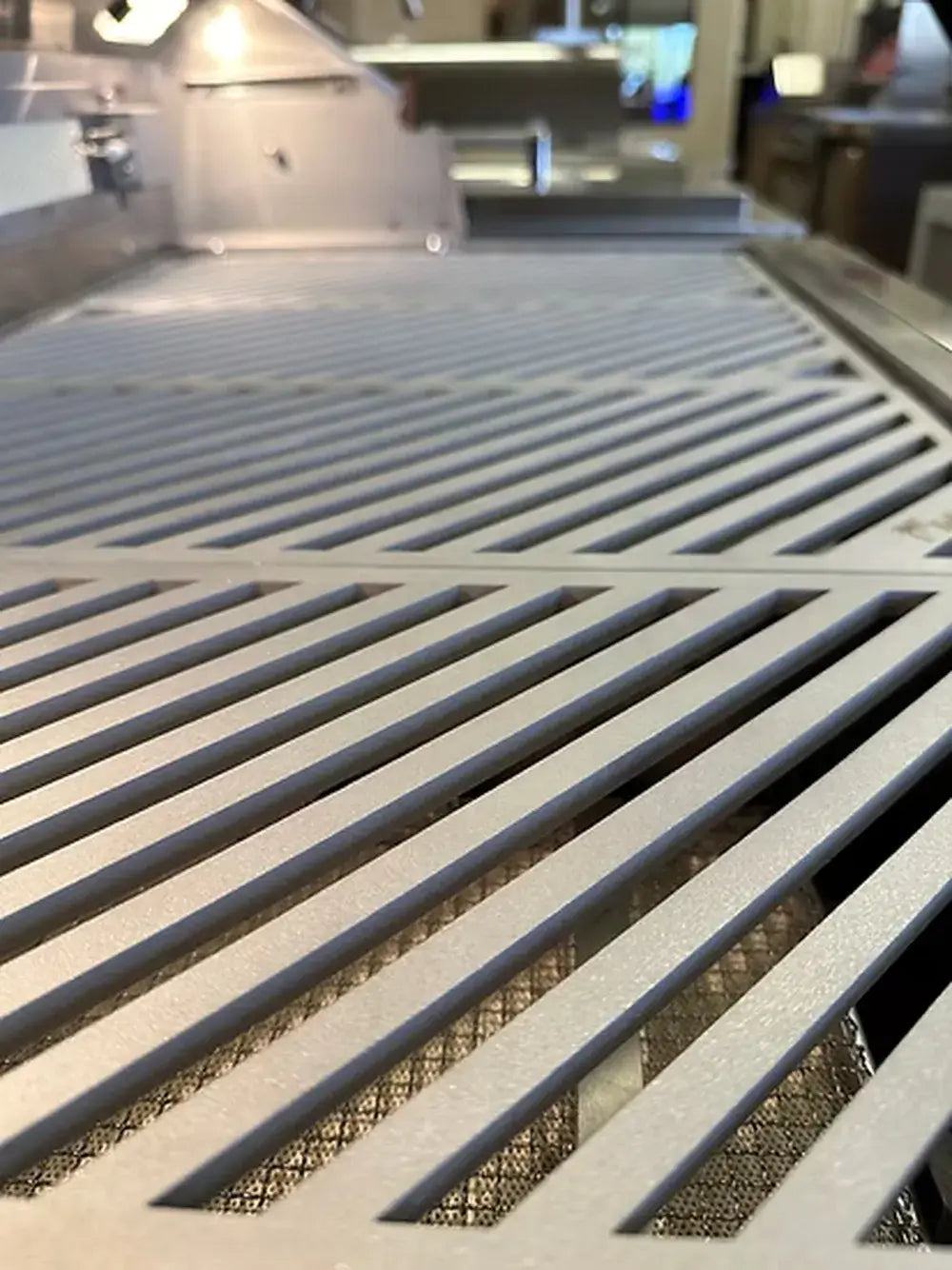 Close-up showing the precise, thick stainless steel bars of the KoKoMo LuxCut laser-cut cooking grates.