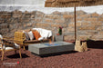 Elementi Plus Monte Carlo 60-inch fire table in light gray with blue fire glass and patio seating.