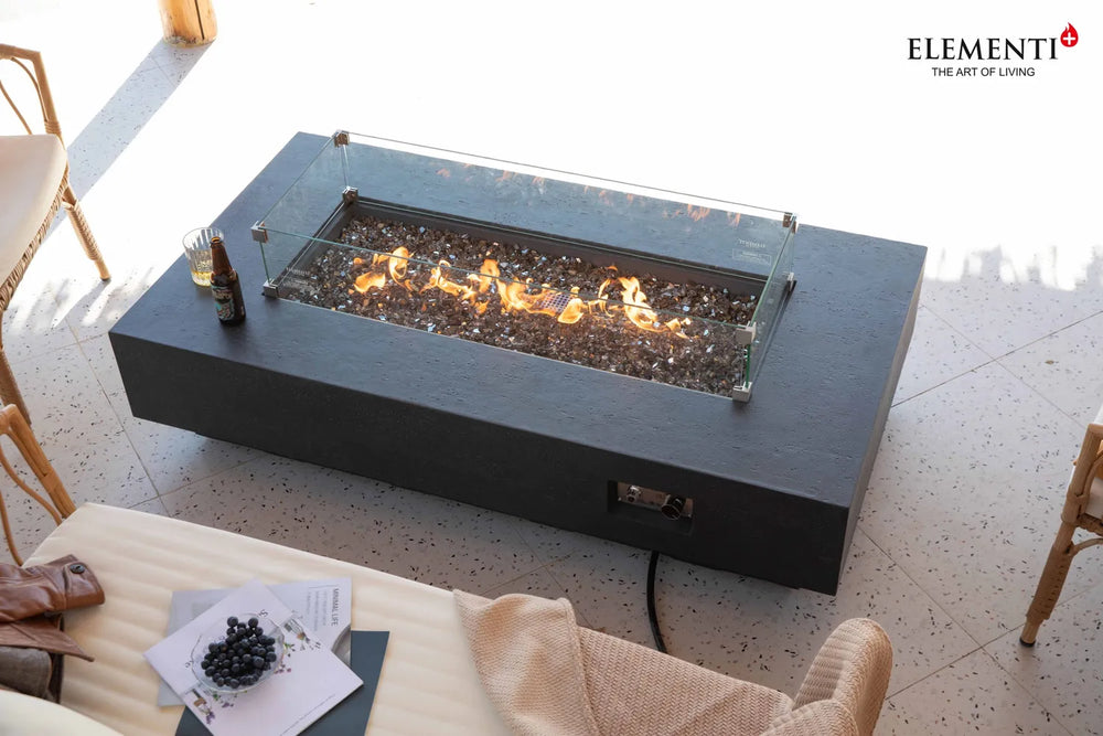 Elementi Plus Positano fire table with glass wind guard and dark fire glass.