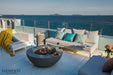 Elementi fire table on a beachfront wooden deck with turquoise pillows and ocean views.