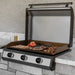 Blackstone built-in 36-inch outdoor gas griddle cooking steak, shrimp, and vegetables on stainless steel drop-in surface