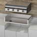 Blackstone 36-inch Drop-In Griddle positioned above the matching stainless steel insulation jacket, ready for installation in a stone outdoor kitchen setup.