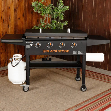 Blackstone 36-inch griddle with hard steel lid and propane tank setup – backyard cooking station