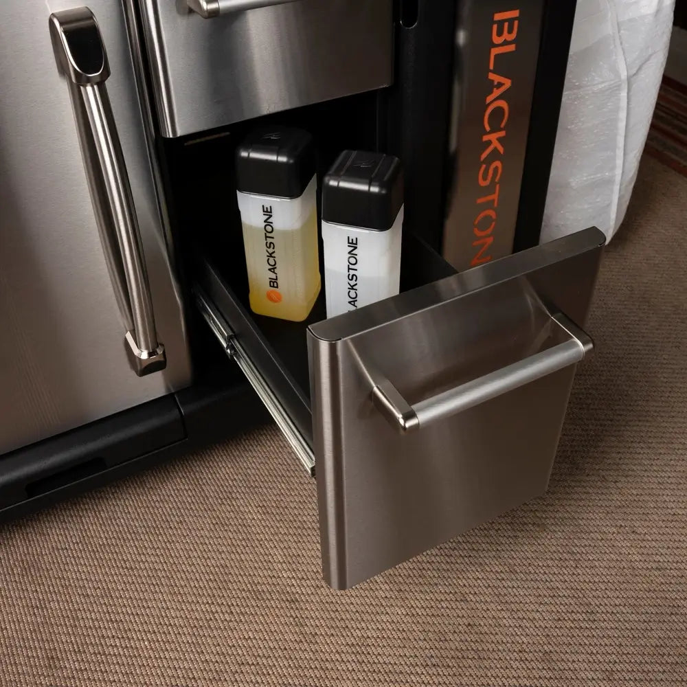 Blackstone oil and water squeeze bottles stored in stainless drawer of 36-inch griddle cabinet
