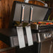 Dual Blackstone stainless steel spatulas hanging on magnetic tool bar of 36-inch griddle side shelf