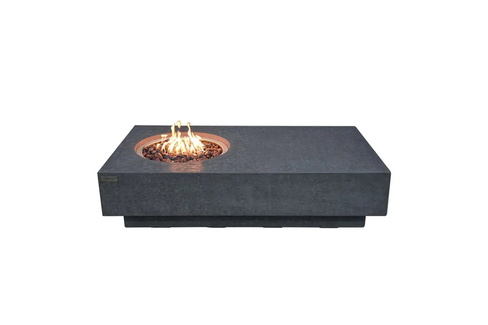 Long rectangular Elementi Metropolis fire table in dark grey GFRC with a circular flame burner and red lava rocks.