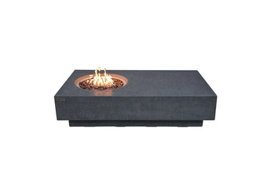 Long rectangular Elementi Metropolis fire table in dark grey GFRC with a circular flame burner and red lava rocks.
