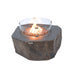 Natural stone-look fire table equipped with a circular tempered glass wind guard.