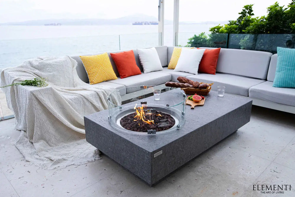 Elementi Metropolis fire table used as a low coffee table for afternoon tea on a luxury seaside terrace.
