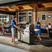 Broil King Regal S 690 Pro IR dual-oven grill in outdoor patio setting with family barbecue