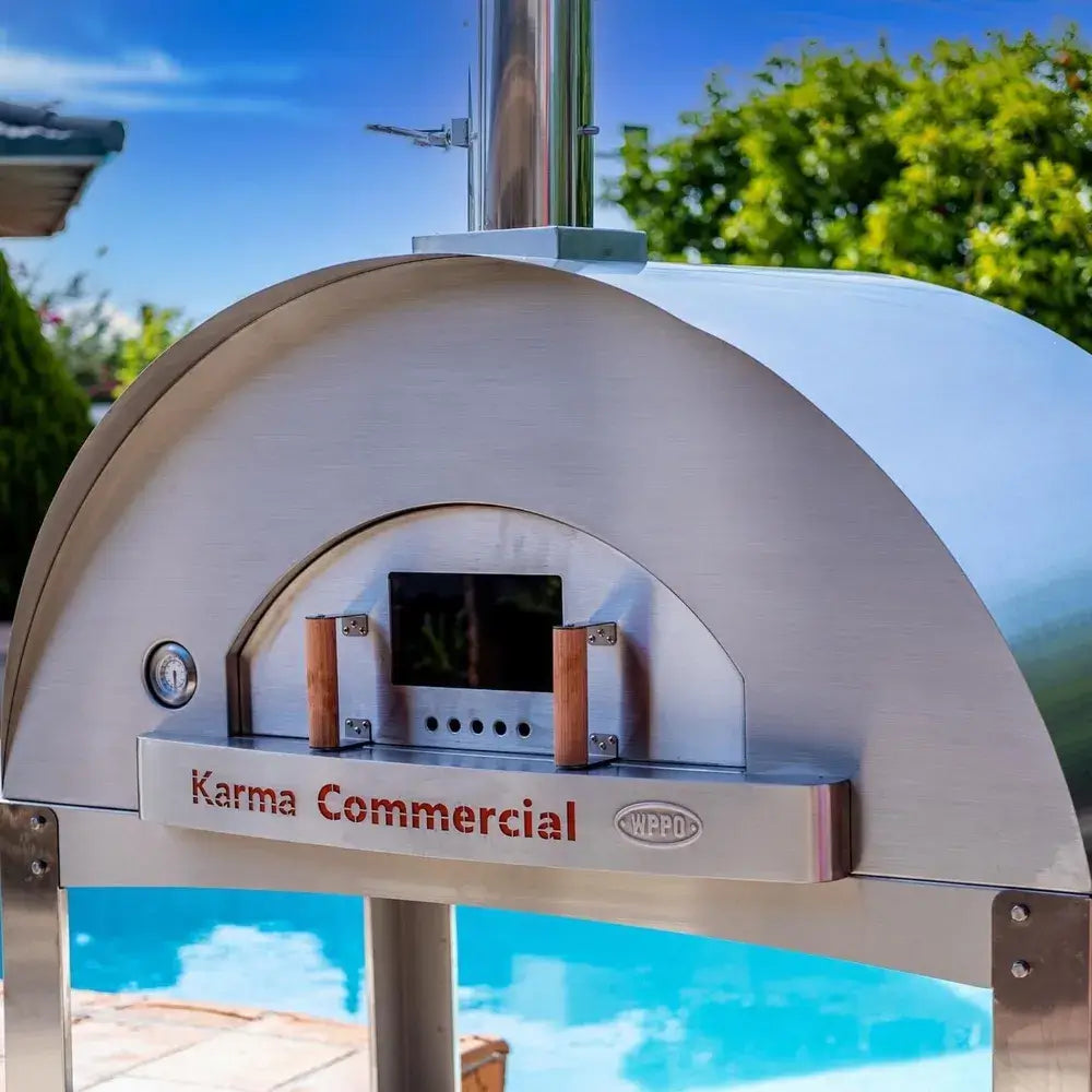 Close-up of WPPO Karma 55 commercial wood-fired oven door with wood handles, thermometer, chimney, and Karma Commercial logo.
