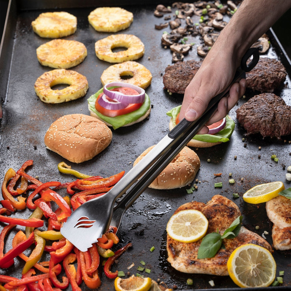 Blackstone Stainless Steel Tongs Flipping Grilled Vegetables on Outdoor Griddle – Precision Griddle Tools in Use