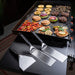 Griddle Tool Kit in Action – Blackstone Deluxe Spatulas and Scraper Beside a Fully Loaded Outdoor Flat Top Grill