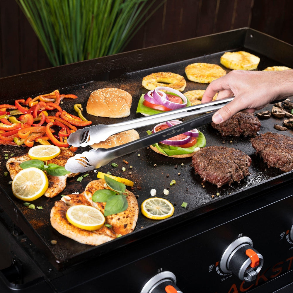 Blackstone Tongs Grabbing Chicken and Vegetables on Flat Top Grill – Premium BBQ Accessories for Griddle Enthusiasts