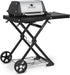 Broil King Porta-Chef AT220 portable gas grill on a folding black wheeled cart, shown in angled front view with stainless steel lid, side shelf, and compact travel-ready design on a light gray background.
