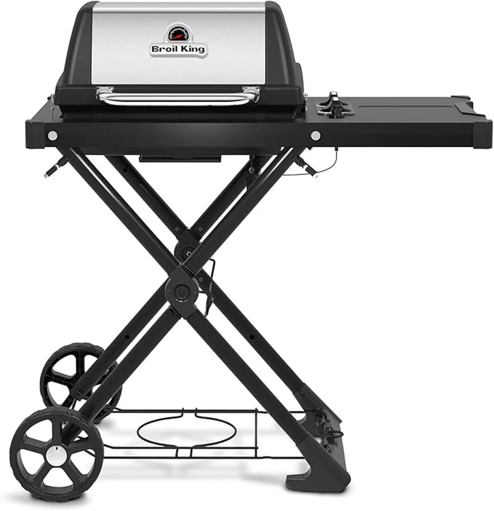 Front view of the Broil King Porta-Chef AT220 portable gas grill with stainless steel hood, black frame, folding scissor-style stand, right side shelf, and lower wire rack for propane storage.