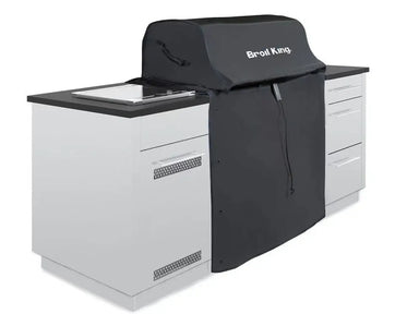 Broil King 68590 grill cover for 600 Series, shown over a grill in a white outdoor kitchen setup.