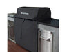 Broil King 68590 600 Series grill cover installed on a built-in grill with stainless outdoor kitchen cabinets.