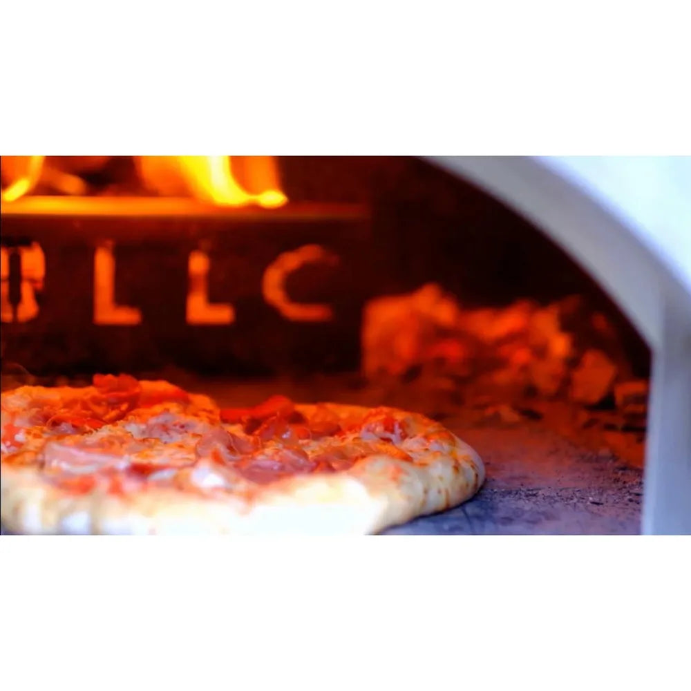 Fresh pizza baking inside a WPPO wood-fired oven next to a glowing wood fire.