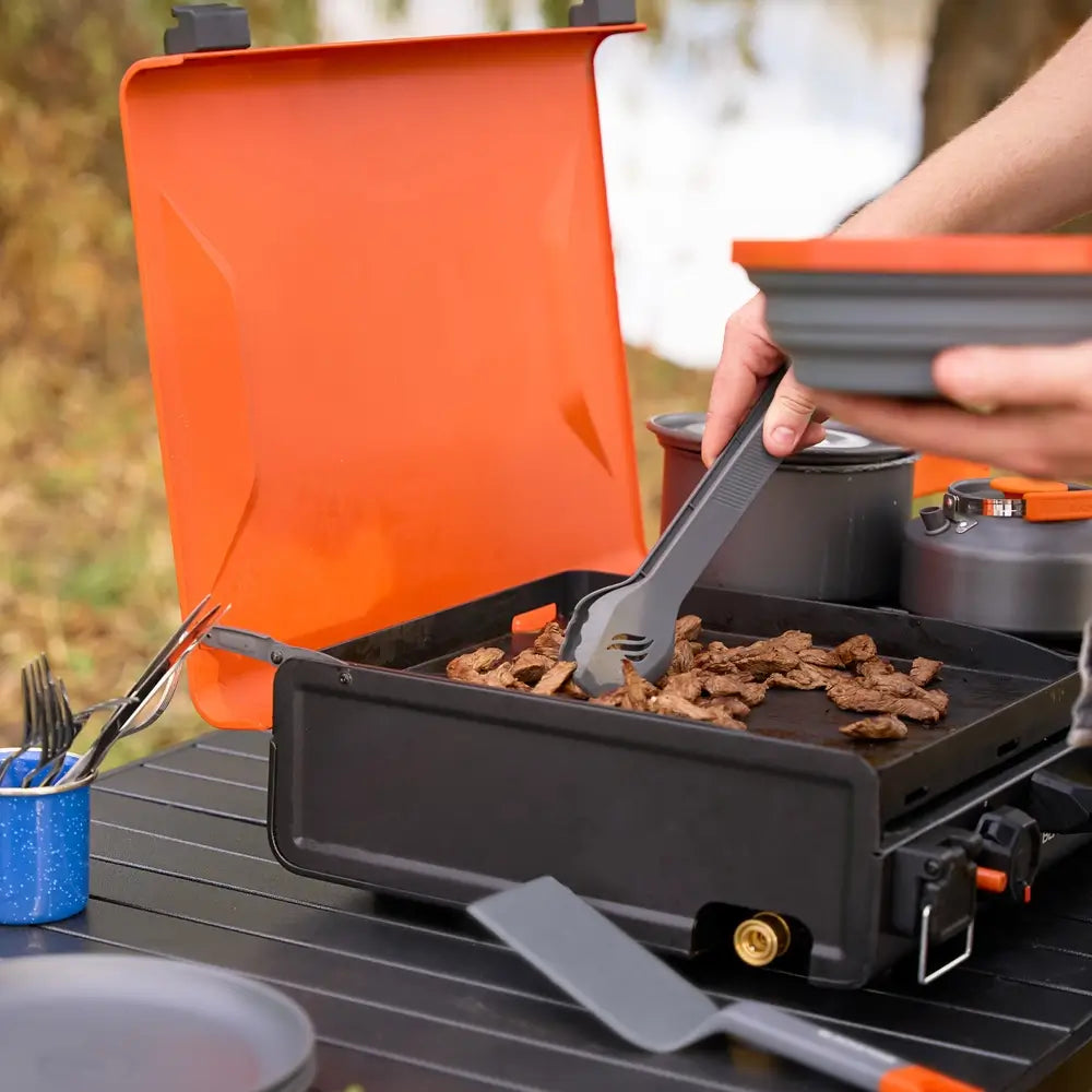 Close-up of adjustable burner knob on portable black camping griddle