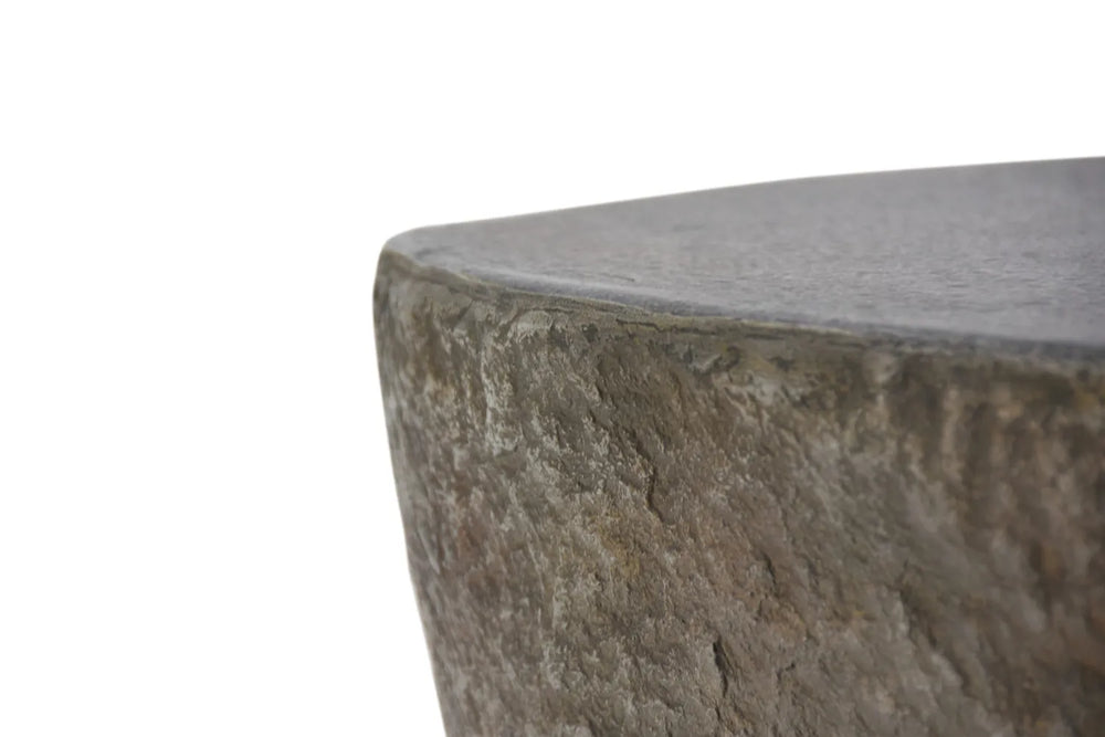 Close-up of the Boulder fire table's edge, highlighting the organic, rugged GFRC stone texture and smooth top surface.