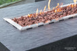 High angle view of a lit Elementi Hampton OFG139DG 56" Dark Gray Fire Table on a modern rooftop patio.