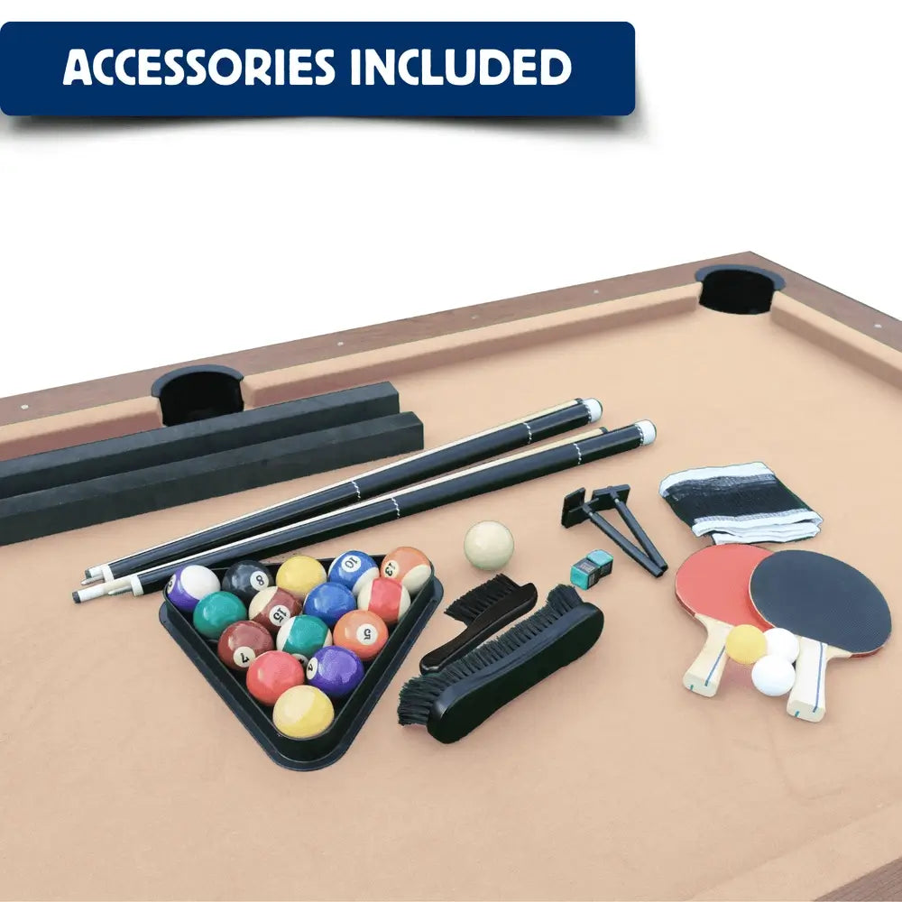 Included game accessories set laid out on tan pool table felt, featuring pool cue sticks, a billiard ball set in a triangle rack, table tennis paddles with balls, a net, chalk, and felt brushes.