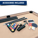 Included game accessories set laid out on tan pool table felt, featuring pool cue sticks, a billiard ball set in a triangle rack, table tennis paddles with balls, a net, chalk, and felt brushes.