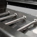 Close-up of stainless steel tube burners inside Broil King Regal S 420 Pro gas grill firebox