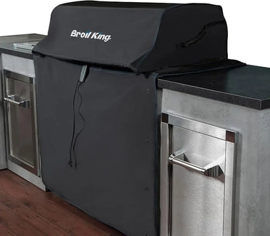 Broil King 68591 grill cover for Imperial 400, shown on a built-in grill in a stainless outdoor kitchen island.