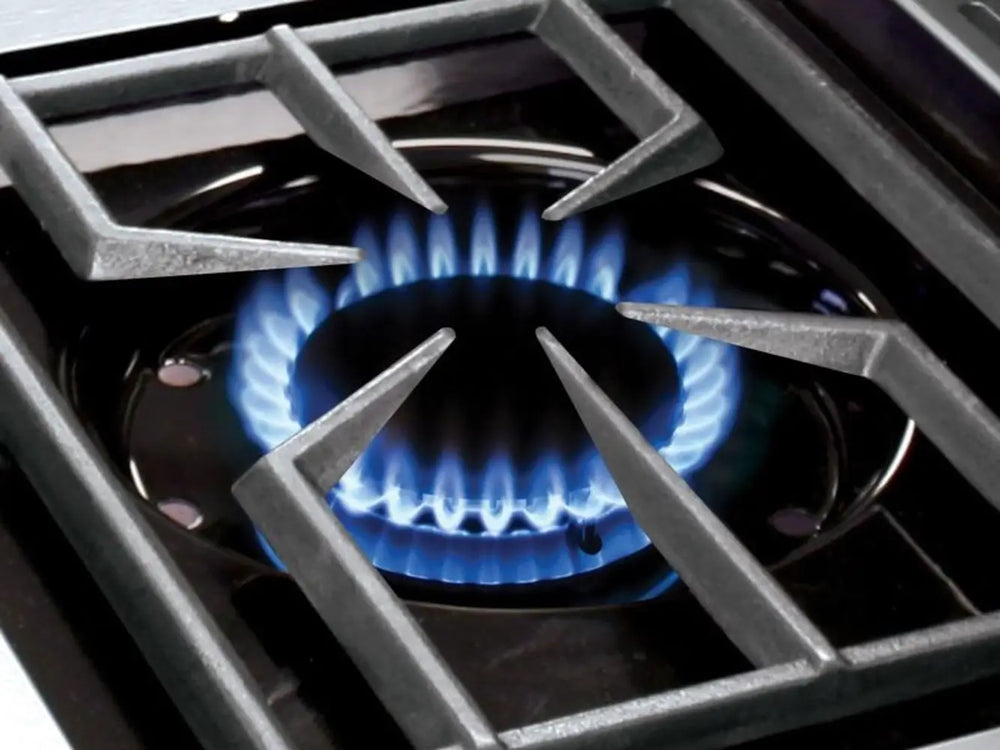 Close-up of a high-performance blue gas flame ignited on a Broil King Imperial series side burner with a heavy-duty cast iron grate.