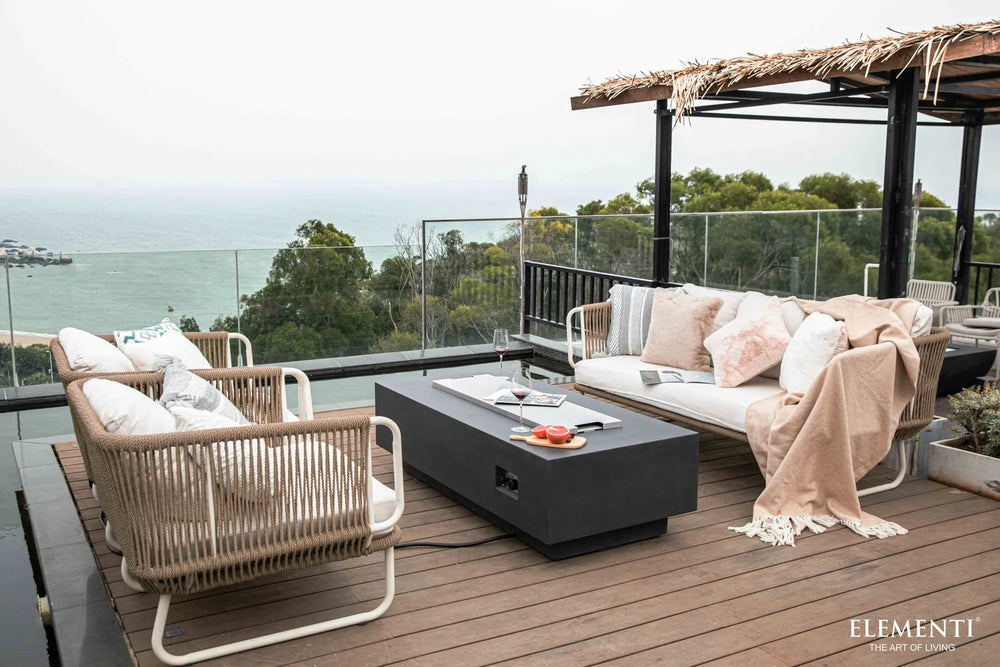 Elementi Granville OFG121DG Fire Table 60" Dark Gray covered with a stainless steel lid on a rooftop terrace.